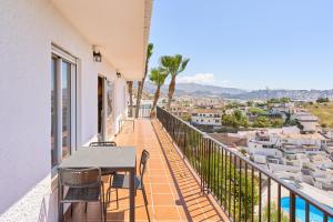 a balcony of a house with a table and chairs at Casa Beto in Almuñécar