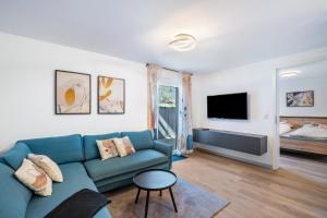a living room with a blue couch and a bed at Fewo Blumenweg in Elzach