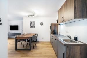a kitchen with a table and a sink and a table at Fewo Blumenweg in Elzach