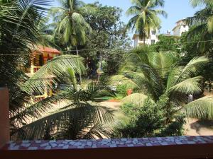 vistas a un jardín con palmeras y edificios en Empire Guest House, en Calangute