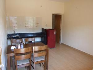 a kitchen with a table and a red refrigerator at Empire Guest House in Calangute