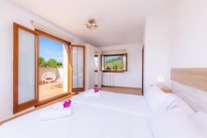 a bedroom with a large bed and a large window at Can Bosco in Son Servera +24 photos