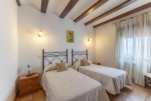 a bedroom with two beds and a window at Casa Rural La Abubilla in Valdelaguna
