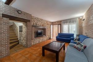 a living room with a blue couch and a brick wall at Casa Rural La Abubilla in Valdelaguna