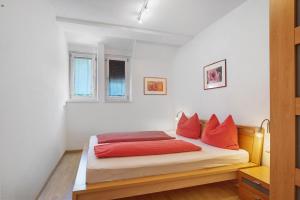 a bedroom with a bed with red pillows on it at Georgshof - Eppan in Appiano sulla Strada del Vino