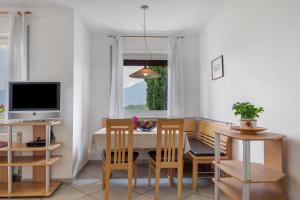 a dining room with a table and chairs and a television at Georgshof - Eppan in Appiano sulla Strada del Vino