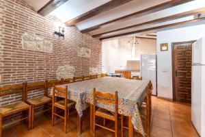 a dining room with a table and chairs and a brick wall at Casa Rural La Abubilla in Valdelaguna
