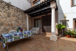 a patio with a table and a stone wall at Casa Rural La Abubilla in Valdelaguna
