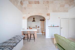 a kitchen and living room with a stone wall at Casita Lemos in Triggianello