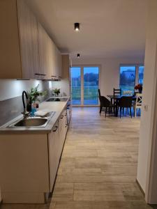 a kitchen with a sink and a dining room at Ferienhäuser Ebbe und Flut in Schülp
