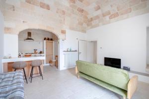 a living room with a green couch and a kitchen at Casita Lemos in Triggianello