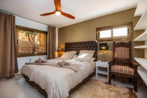 a bedroom with a large bed and a chair at Can Eolo in Capdepera +35 photos