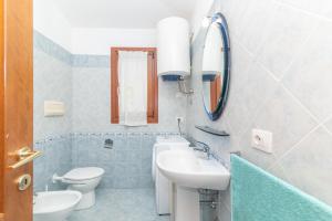 a bathroom with a sink and a toilet and a mirror at Villa San Teodoro in Nuragheddu +13 photos