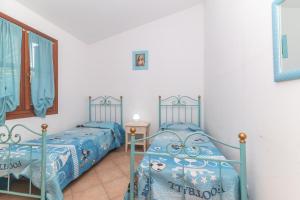 a bedroom with two twin beds and a mirror at Villa San Teodoro in Nuragheddu