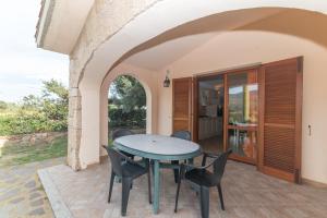 an outdoor patio with a table and chairs at Villa San Teodoro in Nuragheddu