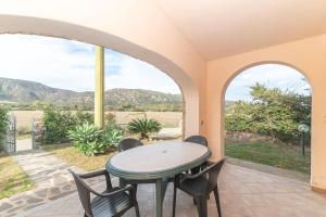 a patio with a table and chairs and a view at Villa San Teodoro in Nuragheddu