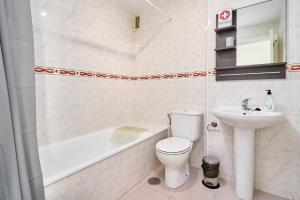 a bathroom with a toilet and a sink and a bath tub at Jardines del Mar in Torrox +17 photos