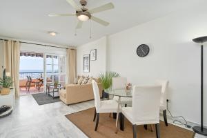 a dining room and living room with a table and chairs at Jardines del Mar in Torrox