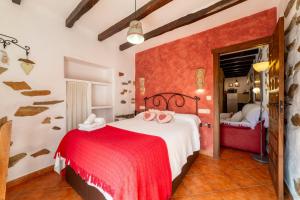 a bedroom with a red and white bed in a room at Picachico in Laroya +18 photos