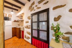 a kitchen with a door and a vase of flowers on a counter at Picachico in Laroya