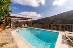 a swimming pool with a mountain in the background at Picachico in Laroya