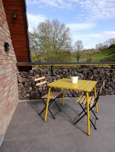 a yellow table and two chairs on a patio at " Al'Coppette " Gîte open-space in Comblain-au-Pont +11 photos