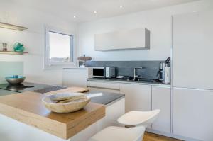 a kitchen with white cabinets and a bowl on a counter at Bodenseepanorama Oberuhldingen in Uhldingen-Mühlhofen