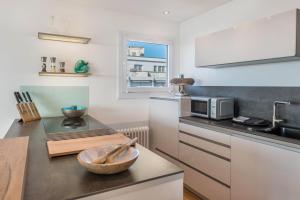a kitchen with a counter top with a microwave and a bowl at Bodenseepanorama Oberuhldingen in Uhldingen-Mühlhofen +34 photos