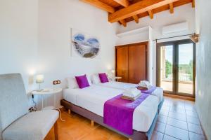 a bedroom with a large white bed and a window at Finca Kiana in Sencelles +34 photos