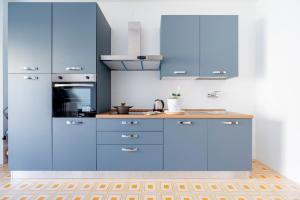 a kitchen with blue cabinets and a stove top oven at Stella Vacanze in Otranto +17 photos