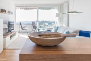 a wooden bowl on a table in a living room at Bodenseepanorama Oberuhldingen in Uhldingen-Mühlhofen
