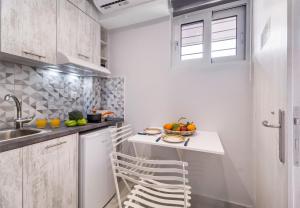 a kitchen with white cabinets and a counter with a sink at Mella Roa - Teal studio in Nydri
