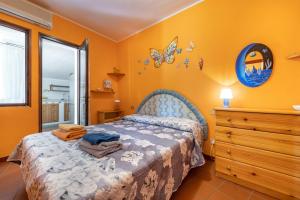 a bedroom with a bed with a blue headboard and a dresser at Casa Marisol in Quartu SantʼElena
