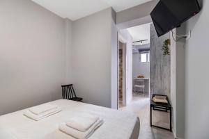 a bedroom with a white bed with two white towels at Mella Roa - Teal studio in Nydri