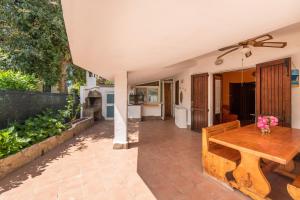 a patio with a wooden table and a dining room at Casa Marisol in Quartu SantʼElena