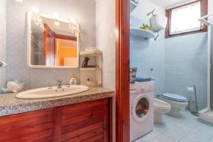 a bathroom with a sink and a washing machine at Casa Marisol in Quartu SantʼElena +18 photos