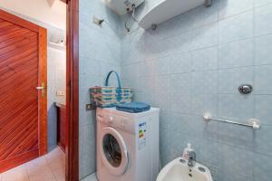 a small bathroom with a washing machine and a toilet at Casa Marisol in Quartu SantʼElena