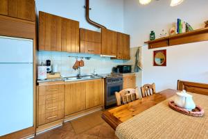 a kitchen with wooden cabinets and a table with a table at Casa Bruna - 100m dal Lago Maggiore in  Monvalle 