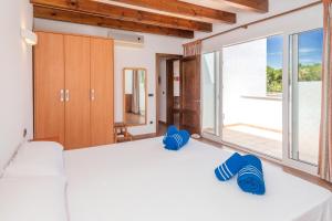 a bedroom with a bed with blue slippers on it at Villa Payu in Ciutadella +17 photos