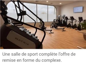 a gym with a bunch of exercise equipment in a room at Gîte Le Flot in Saint-Florentin