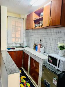 a small kitchen with a counter and a microwave at Nimaai Apartment in Narok