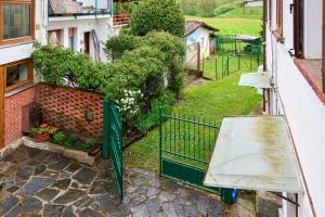 a balcony with a green gate and a building at Casa Bruna - 100m dal Lago Maggiore in  Monvalle  +2 photos