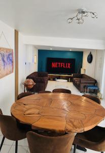 a wooden table and chairs in a living room at Gîte Le Flot in Saint-Florentin