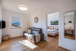 a living room with a couch and a mirror at Meine Bleibe Apartment Terra in Appiano sulla Strada del Vino