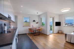 a kitchen and living room with a table and chairs at Meine Bleibe Apartment Terra in Appiano sulla Strada del Vino +21 photos