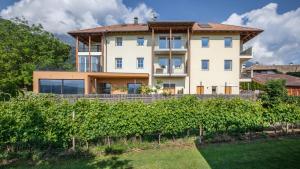 a large white house with a lot of bushes at Meine Bleibe Apartment Terra in Appiano sulla Strada del Vino
