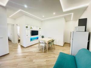 a living room with a table and a refrigerator at Villa Raffaella - Privat Garden in Bibione
