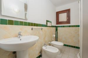 a bathroom with a sink and a toilet at Residence Orizzonti app n 21 in Golfo Aranci +18 photos