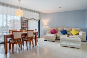 a living room with a couch and a table and chairs at Ática Blue Sea in Cubelles