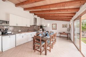 a kitchen with white cabinets and a wooden ceiling at Villa Agnes in Pollença